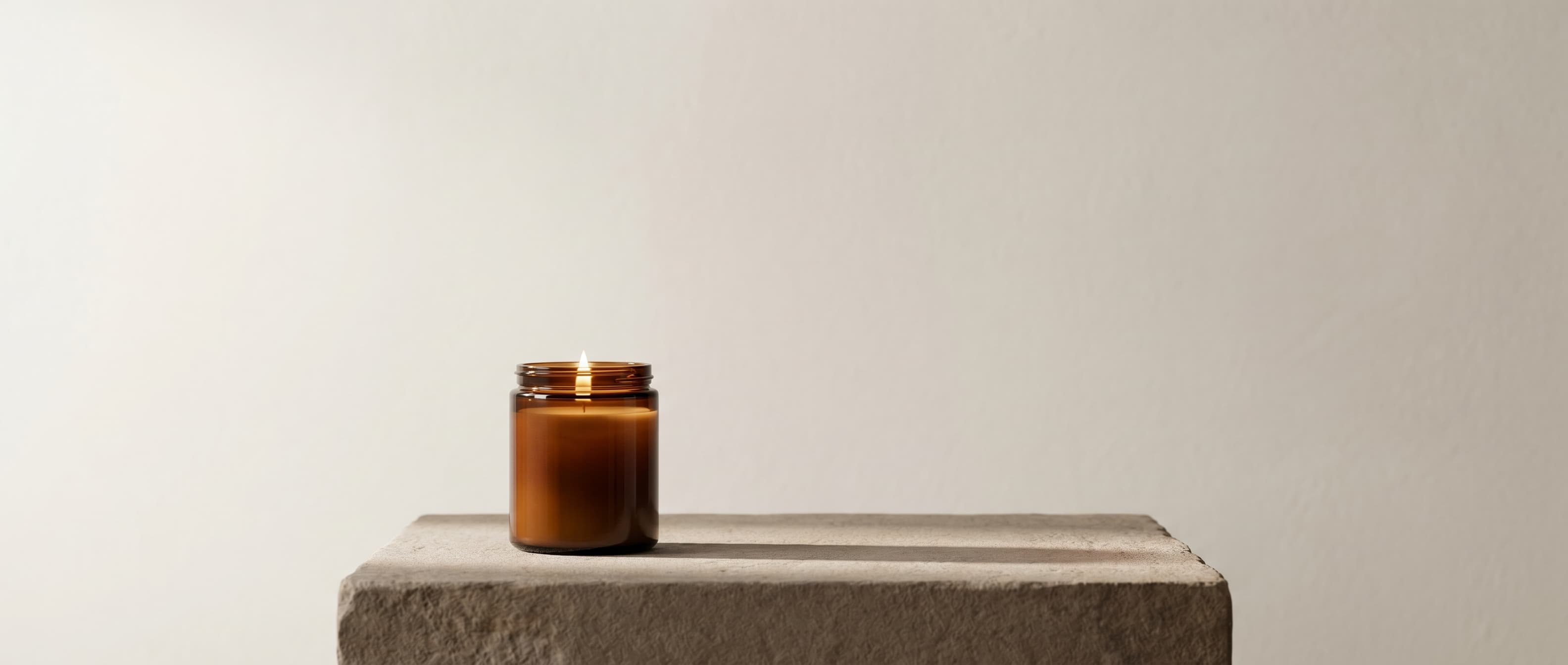 Cravista candle in amber jar, hero shot on a minimal surface