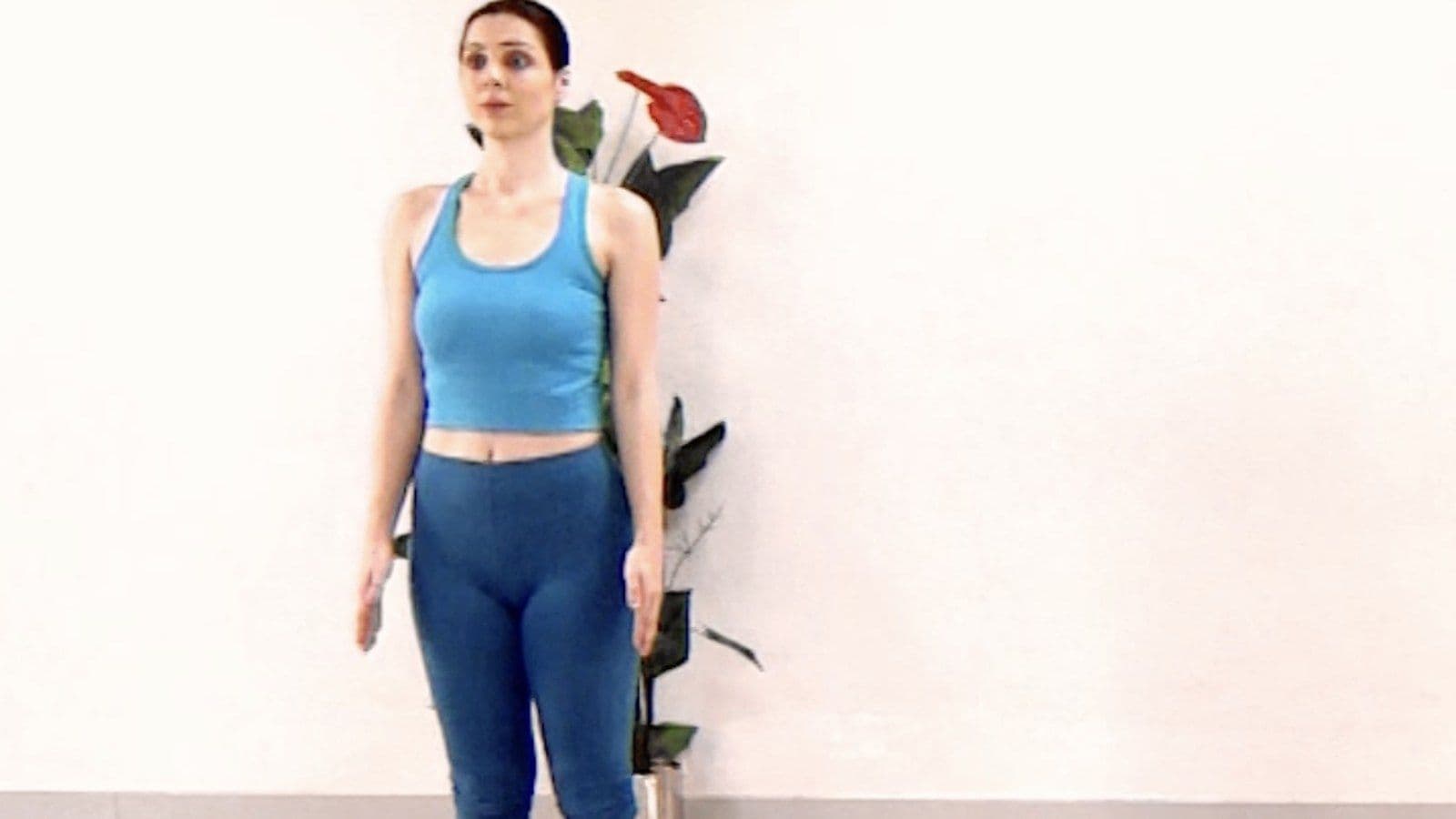 A morning yoga practice — three practitioners standing on mats in a bright studio.